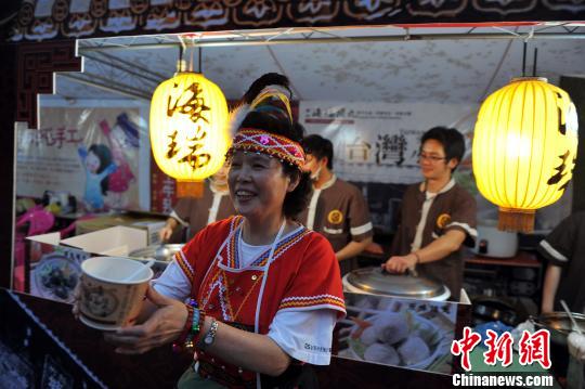 10月26日晚，一位身穿臺(tái)灣阿美族服飾的阿嬤在向民眾推介美味的臺(tái)灣小吃