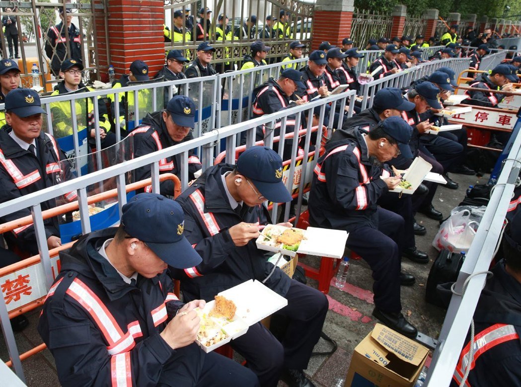 日前“一例一休”爭議，大批警力如臨大敵，駐守“立法院”，避免抗議民眾翻墻進(jìn)入“立法院”，飯點到了就地吃便當(dāng)