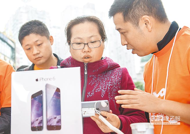 iphone 6上市活動現(xiàn)場，工作人員在為消費者解答關(guān)於新機的問