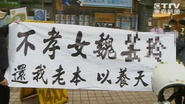 70歲老夫婦上街高舉白布條抗議女兒借200萬不還，害他們半年都繳不出健保費。（臺媒圖）