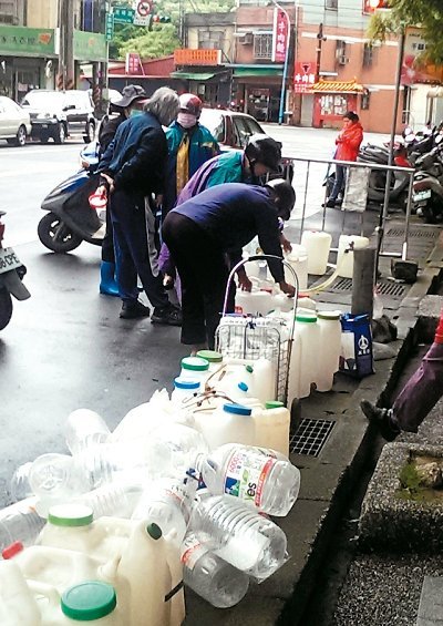 桃園市限水首日，龜山精忠裏的免費(fèi)山泉水前等待裝水的空瓶、空桶大排長龍。