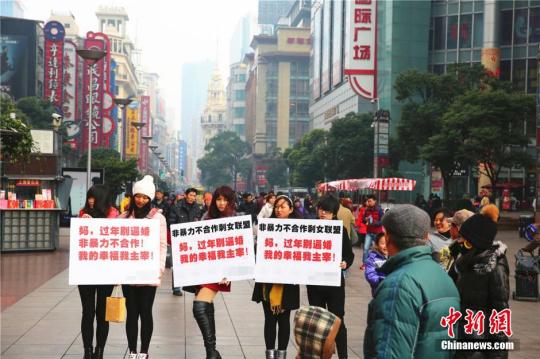 資料圖：2015年2月4日，幾位女青年手舉標(biāo)語出現(xiàn)在上海鬧市區(qū)，無聲地抗議親友的逼婚行為，其標(biāo)語上寫著“媽，過年回家別逼婚。我的幸福我主宰！”中新社發(fā) 章渝 攝 圖片來源：CNSPHOTO