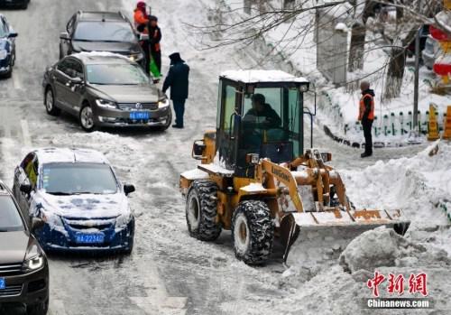 在烏魯木齊市區(qū)，大型機(jī)械設(shè)備出動(dòng)清理道路上的積雪。 中新社記者 劉新 攝