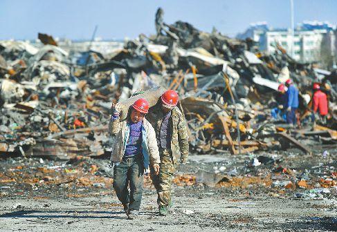 15日,工作人員在火災(zāi)後的匡山酒水批發(fā)市場內(nèi)清理現(xiàn)場。