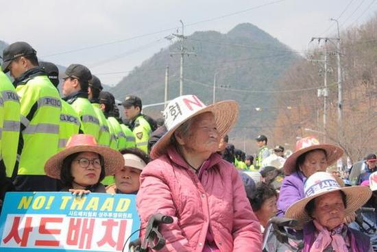 3月29日，星州高爾夫球場附近，村裏奶奶們坐在卡車欲經(jīng)過的路上